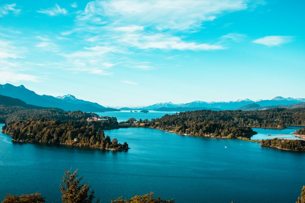 Turquoise lakes surrounded by dense forests and snow-capped Andes mountains in Bariloche, Patagonia.