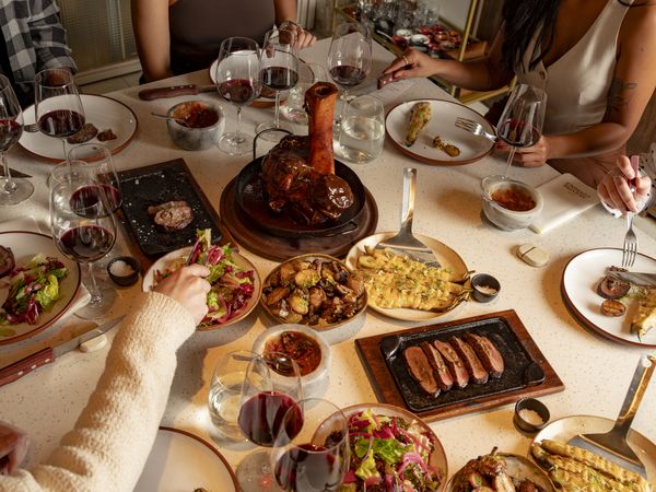 Argentine feast in Buenos Aires featuring grilled meats, wine, and traditional dishes shared family-style at an upscale dining experience.