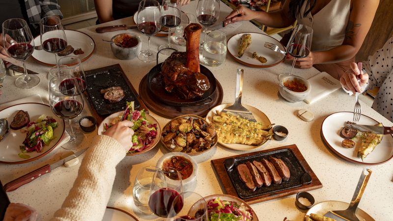 Argentine feast in Buenos Aires featuring grilled meats, wine, and traditional dishes shared family-style at an upscale dining experience.