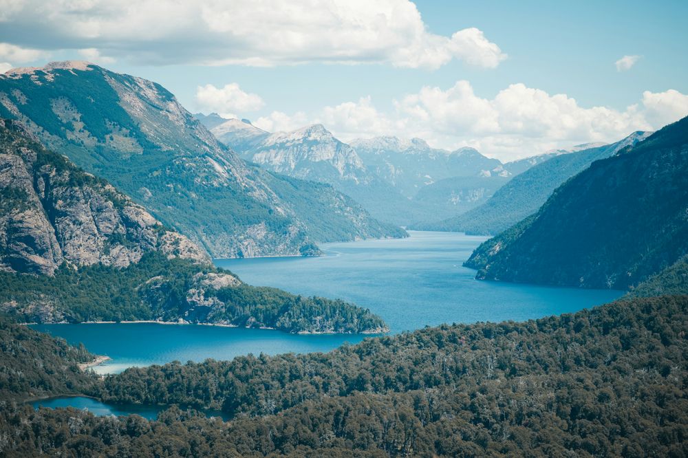 Turquoise lakes nestled among forested mountains and snow-capped peaks in the Lake District near Bariloche, Argentina.