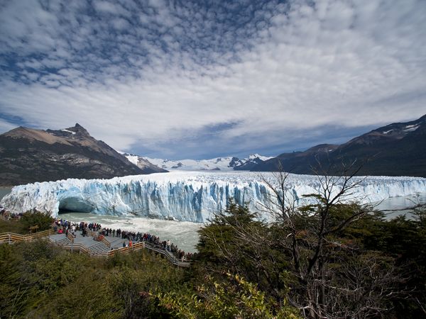 Visitors on wooden walkways view the massive blue ice walls of Glaciar Perito Moreno in El Calafate, Patagonia.