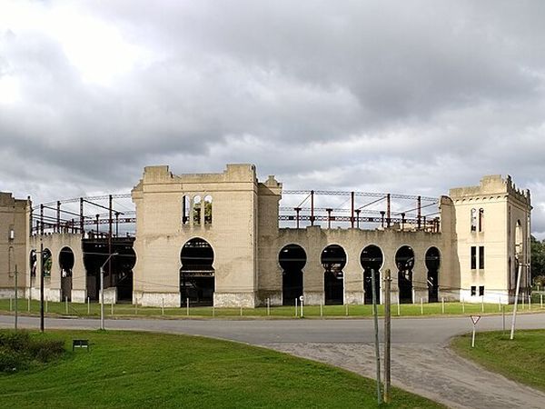 Historic cream-colored fortress with castle towers and arched openings in Colonia del Sacramento, Uruguay.