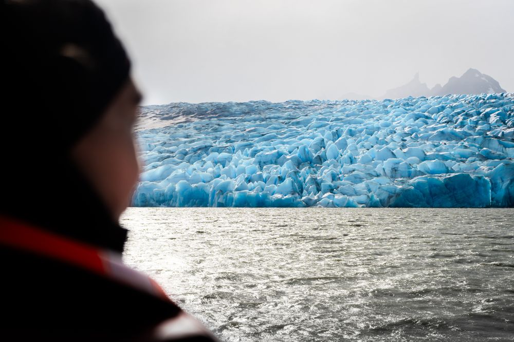 Traveler gazes at the stunning blue ice formations of Glaciar Grey in Torres del Paine National Park, Patagonia.