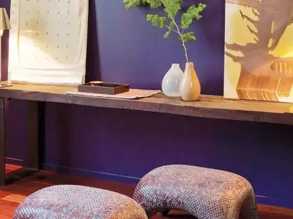 Modern luxury hotel lounge with purple walls, wooden console table, and contemporary furnishings in Esplendor.