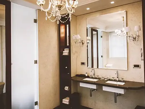 Luxurious bathroom at Park Hyatt featuring dual sinks, dark wood accents, crystal chandelier, and marble finishes.