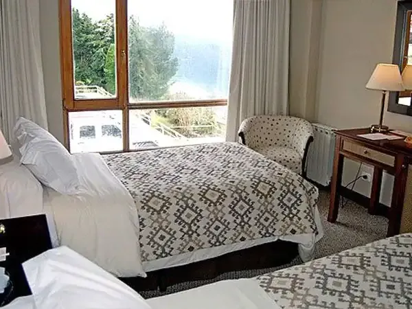Spacious hotel bedroom with lake views, twin beds, desk, and modern amenities at Incayal resort in Patagonia.