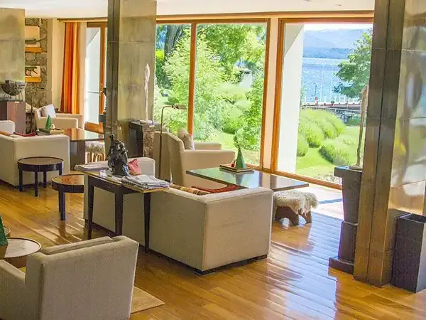 Luxury lodge interior in Casco with panoramic views of lake, mountains, and waterfront through floor-to-ceiling windows.