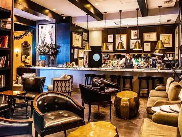 Luxurious lounge bar in Santiago featuring gold and black decor, leather seating, and sophisticated ambiance.