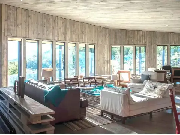Luxury lodge interior at Awasi with floor-to-ceiling windows overlooking Patagonian landscape and modern furnishings.