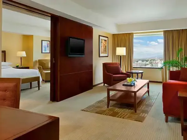 Luxurious hotel suite at Sheraton Mendoza with city views, modern furnishings, and warm earth-tone décor.