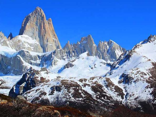 Mount Fitz Roy towers above snow-covered peaks and glaciers in El Chaltén, Patagonia, Argentina.