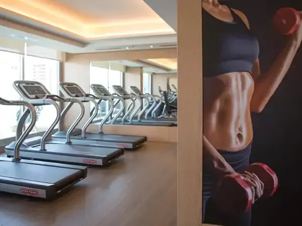 Modern gym with treadmills and motivational fitness poster at Palladio Hotel.