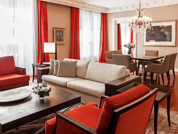 Luxurious Park Hyatt hotel suite with red and cream furnishings, marble coffee table, and elegant chandelier in Buenos Aires.