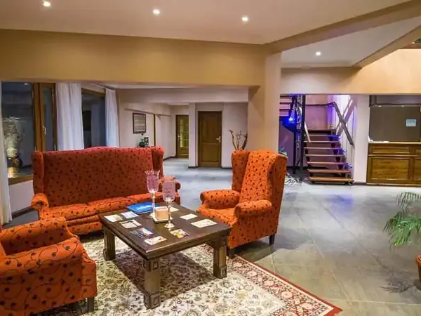 El Chaltén luxury hotel lobby with orange patterned seating, dark wood furniture, and modern staircase.