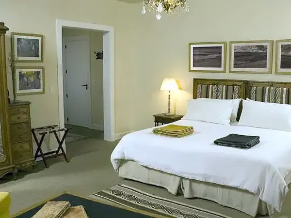 Luxurious bedroom at Eolo Patagonia's Spirit hotel with panoramic views, elegant furnishings, and modern amenities.