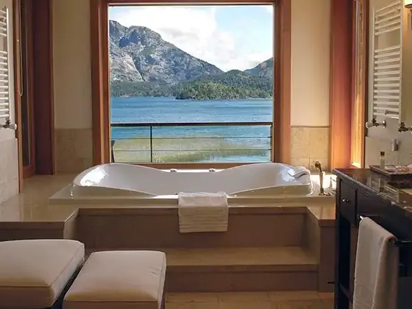 Luxury bathroom at Llao Llao Hotel with soaking tub overlooking Nahuel Huapi Lake and mountain peaks in Bariloche.