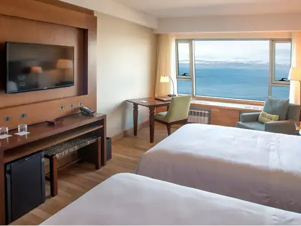 Luxury hotel room at Arakur Ushuaia with twin beds, flat-screen TV, and panoramic views of the Beagle Channel.