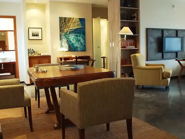 Territorio hotel suite in Buenos Aires features mid-century modern furniture, warm wood tones, and contemporary artwork throughout the elegant living space.