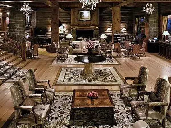 Luxurious lodge interior at Llao Llao with rustic wood beams, elegant furnishings, stone fireplace, and panoramic windows overlooking Patagonian landscapes.