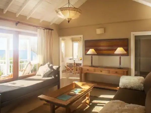Bright beachfront bedroom at Los Ponchos with ocean views, wooden furniture, and comfortable seating area.