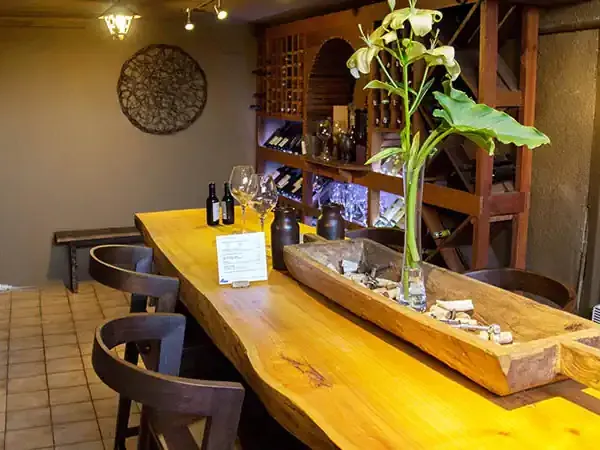 Elegant dining room at Ecohotel Carmenere with yellow wooden tables, wine display, and natural décor in Patagonia.