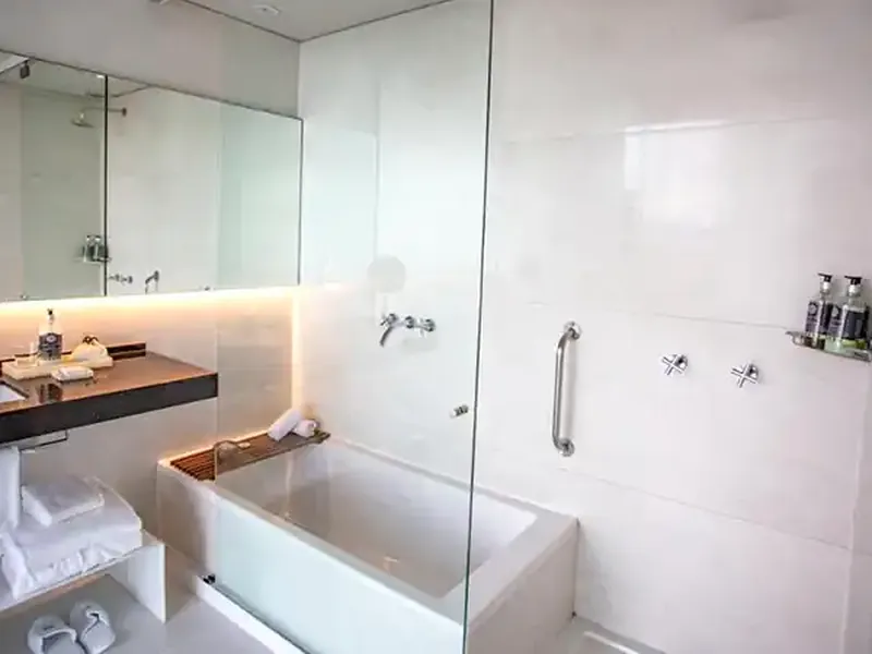 Modern luxury bathroom with marble finishes, heated mirror, rainfall shower, and heated towel rack at Casa de Uco.