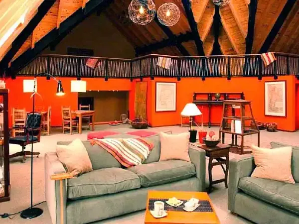 Vibrant orange lodge interior with exposed beams, comfortable seating, and rustic décor at Los Cerros Boutique Hotel.
