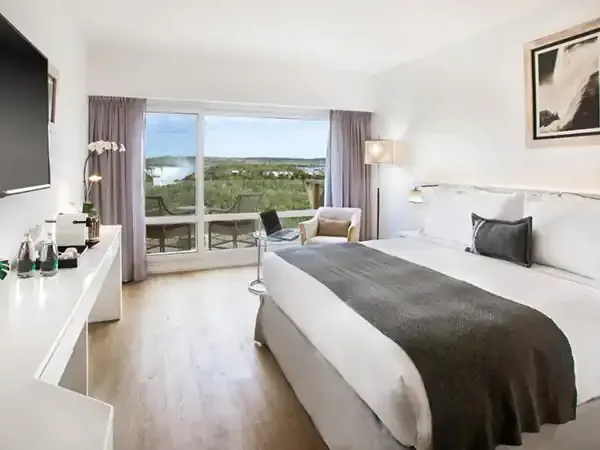 Luxurious hotel bedroom at Gran Meliá Iguazú with panoramic views of lush Misiones landscape and modern amenities.
