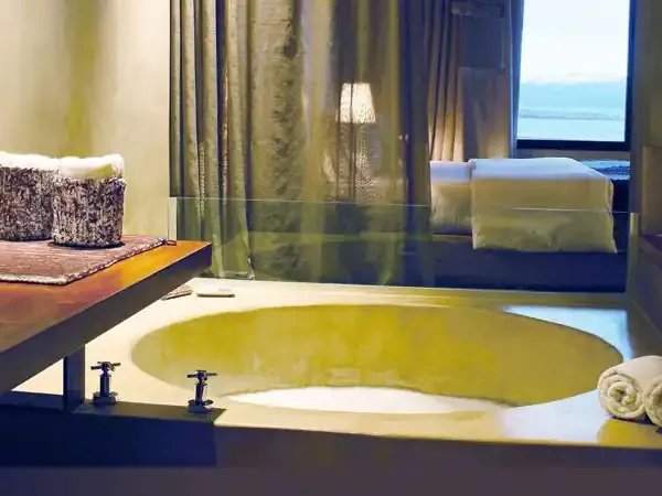 Luxurious hotel bathroom with sunken bathtub overlooking ocean views in Patagonia.