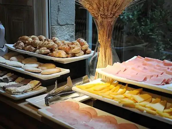 Buffet display of cured meats, cheeses, pastries and bread at a traditional Argentine asado restaurant.