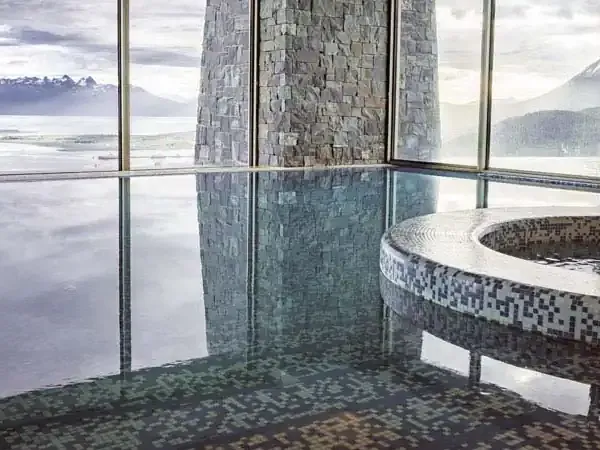 Modern spa with panoramic views of Beagle Channel and Ushuaia mountains through floor-to-ceiling windows.