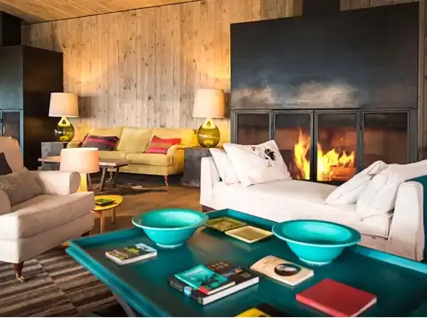 Luxury lodge interior at Awasi with fireplace, turquoise accents, and modern furnishings creating an upscale Patagonian retreat.