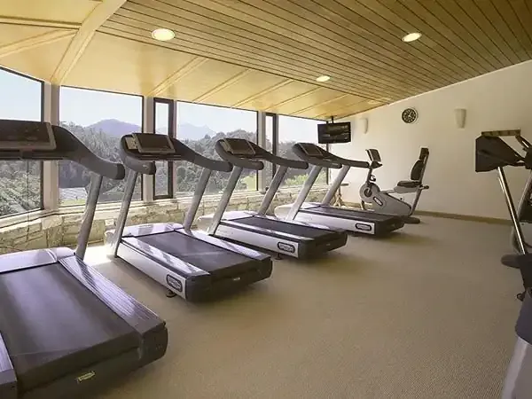 Modern gym with treadmills overlooking Llao Llao lake and Patagonian mountains in Argentina.