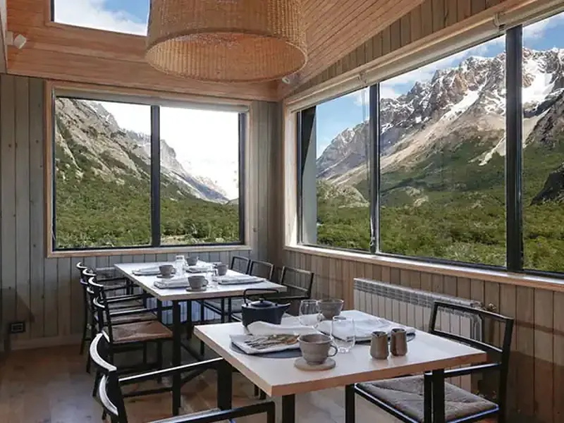 Modern dining room with mountain views at Explora Chaltén lodge overlooking Patagonian peaks and valleys.