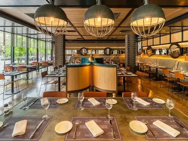Modern restaurant interior at Hyatt Centric Santiago with elegant dining setup, warm lighting, and contemporary design overlooking the city.