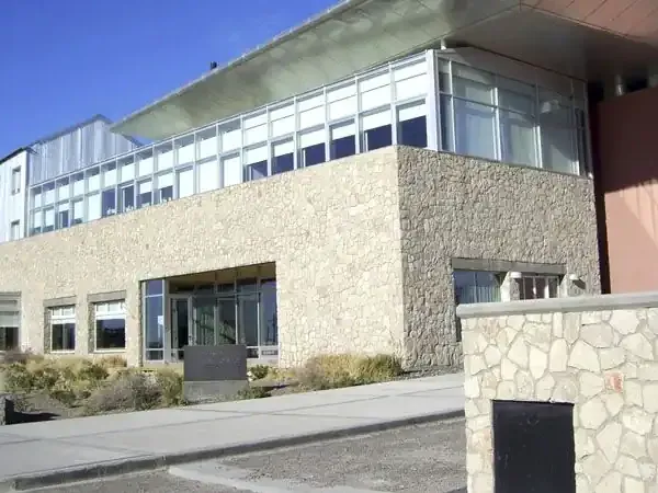 Modern architecture building with stone and terracotta facade in Territorio, Patagonia, featuring contemporary design under clear blue sky.