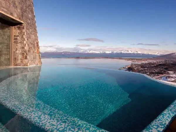 Infinity pool at Arakur overlooking Beagle Channel and snow-capped mountains in Ushuaia, Patagonia.
