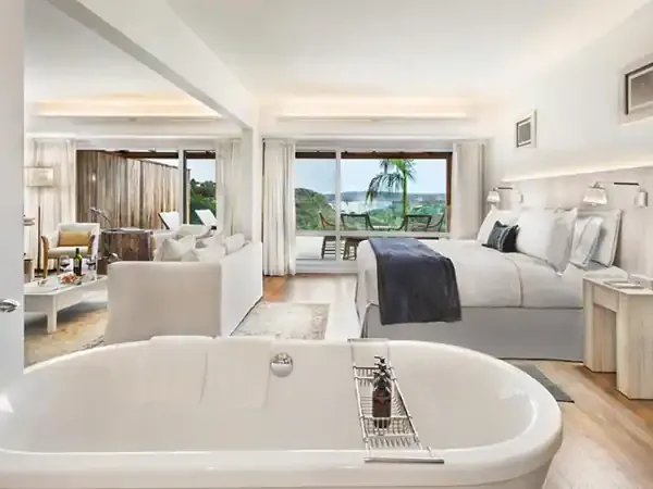 Luxury suite at Gran Meliá Iguazú with freestanding bath, king bed, and panoramic views of the Iguazú Falls and surrounding landscape.