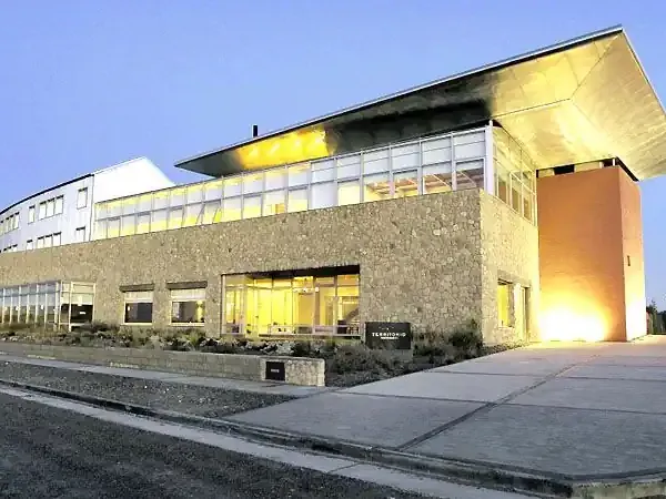 Modern architectural building illuminated at dusk in Territorio, Patagonia, showcasing contemporary design and landscape.