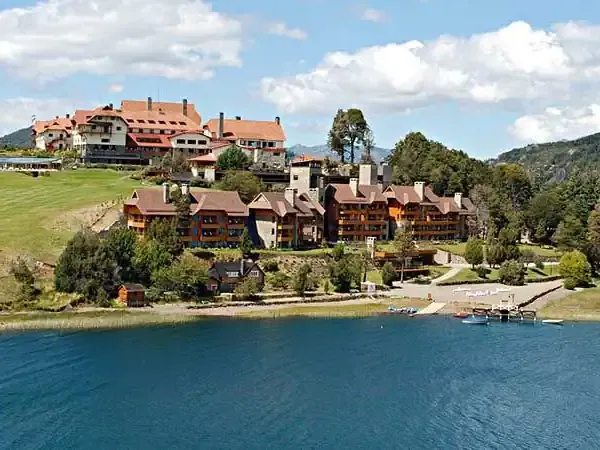 Llao Llao Hotel overlooks turquoise Lake Nahuel Huapi surrounded by Patagonian forests and mountains in Bariloche, Argentina.