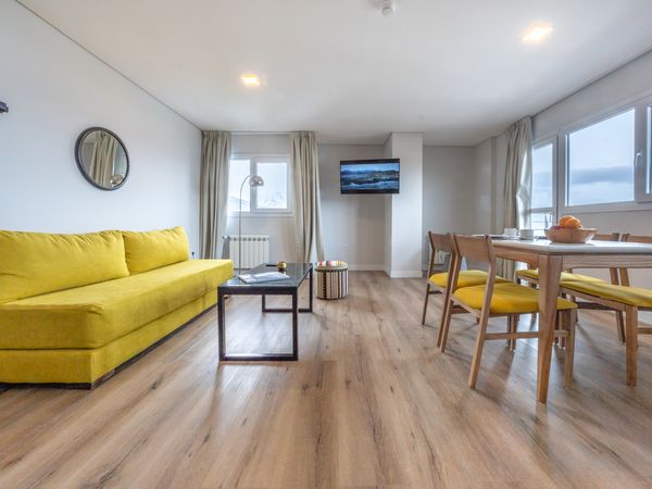 Modern bright yellow living room with waterfront views in Tierra del Fuego accommodation.