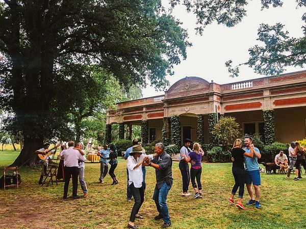 Guests dancing and socializing on the lawn of a historic estancia in San Antonio de Areco, Buenos Aires.