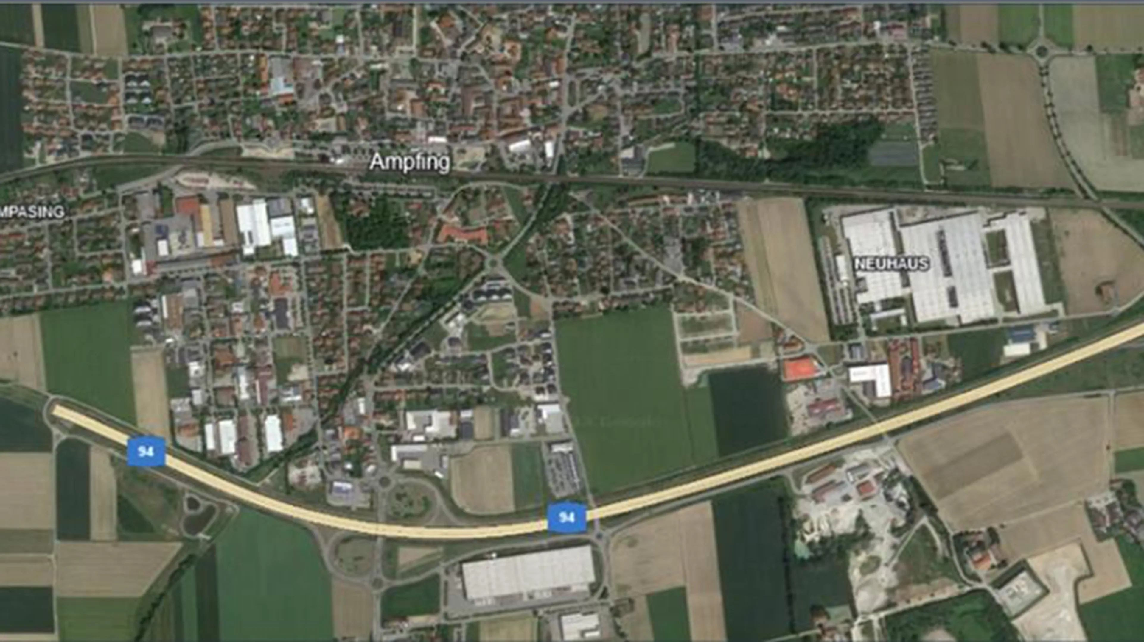 Aerial view of a town with roads, fields, and various buildings, intersected by a highway labeled A4.