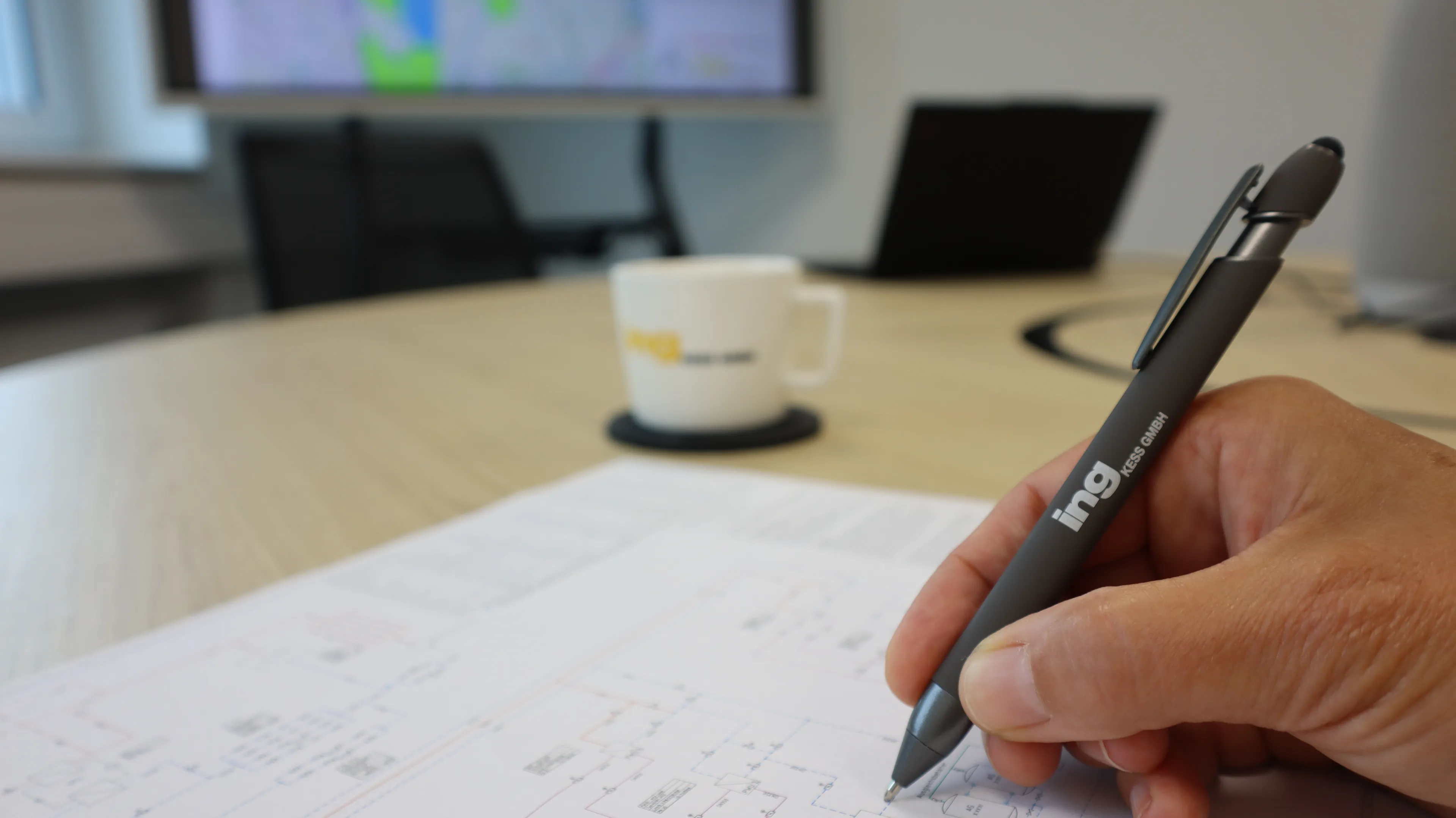 Mit Stift der Firma ing Kess wird auf einem Plan geschrieben