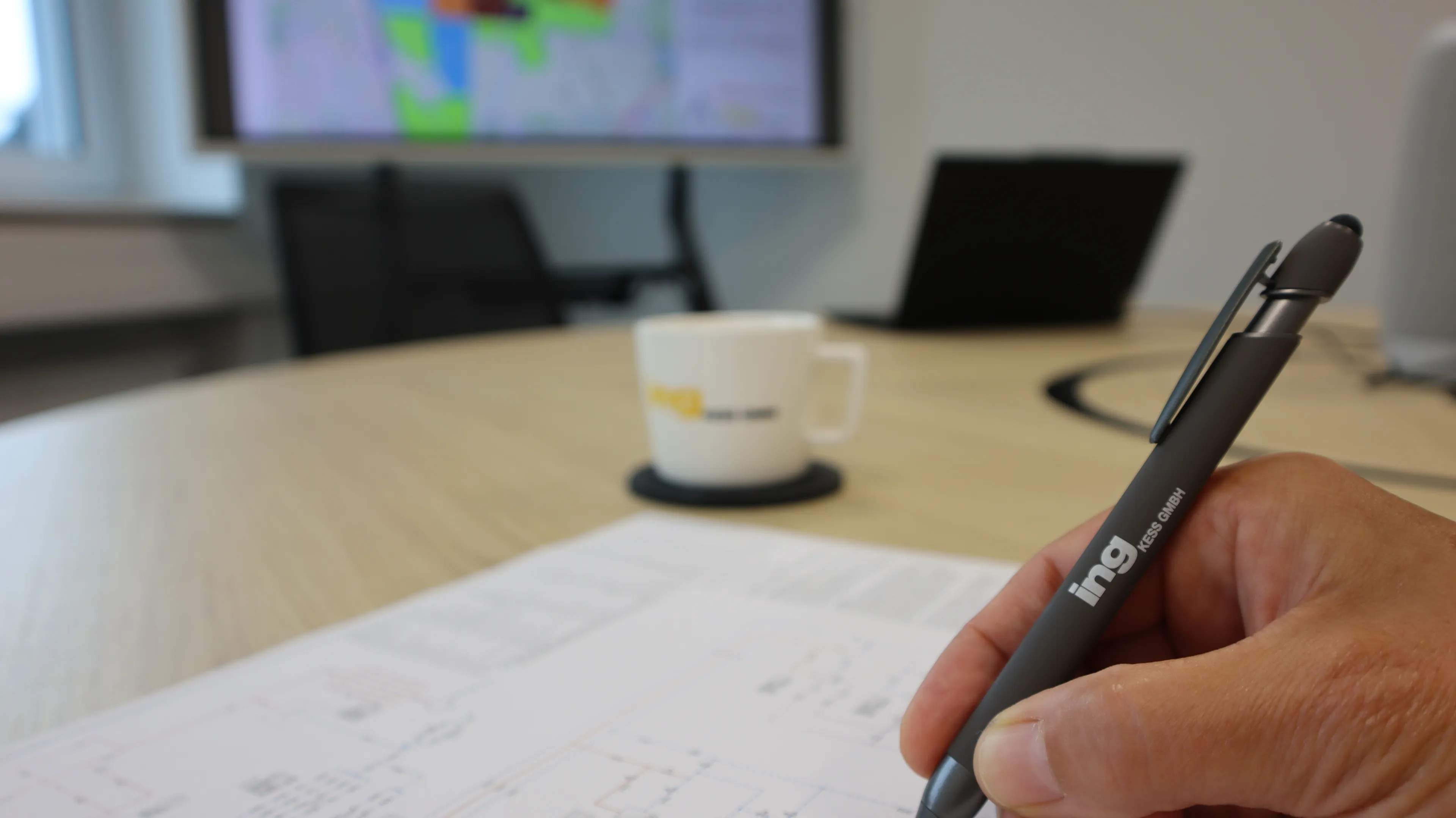 Mit Stift der Firma ing Kess wird auf einem Plan geschrieben