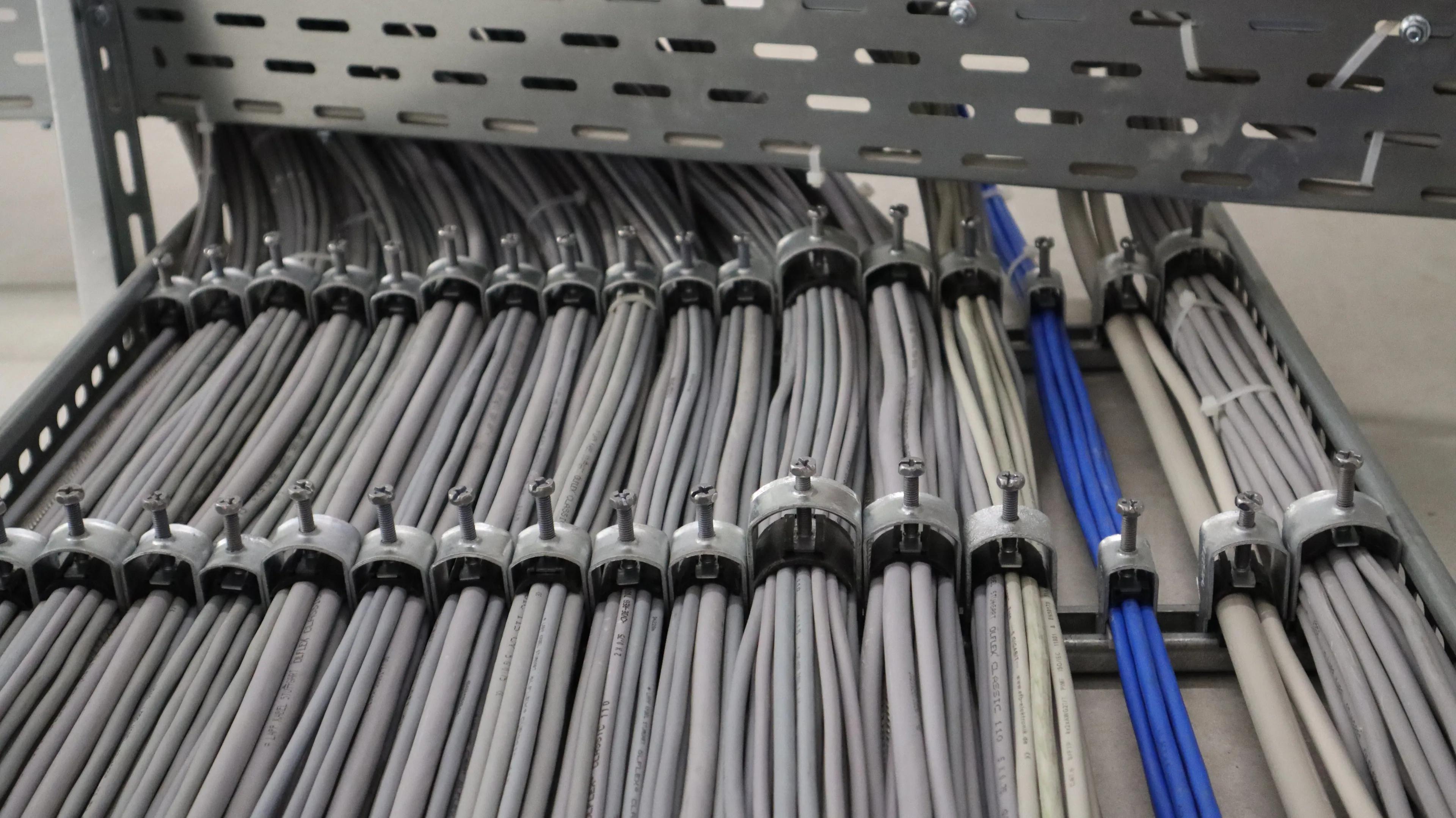 Mehrere sauber verlegte Energie-, Steuerungs- und Datenkabel in einer industriellen Anlage. Die strukturierte Kabelführung sorgt für eine sichere Stromversorgung, Signalübertragung und Vernetzung technischer Systeme sowie Automatisierungskomponenten.