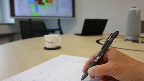 Mit Stift der Firma ing Kess wird auf einem Plan geschrieben