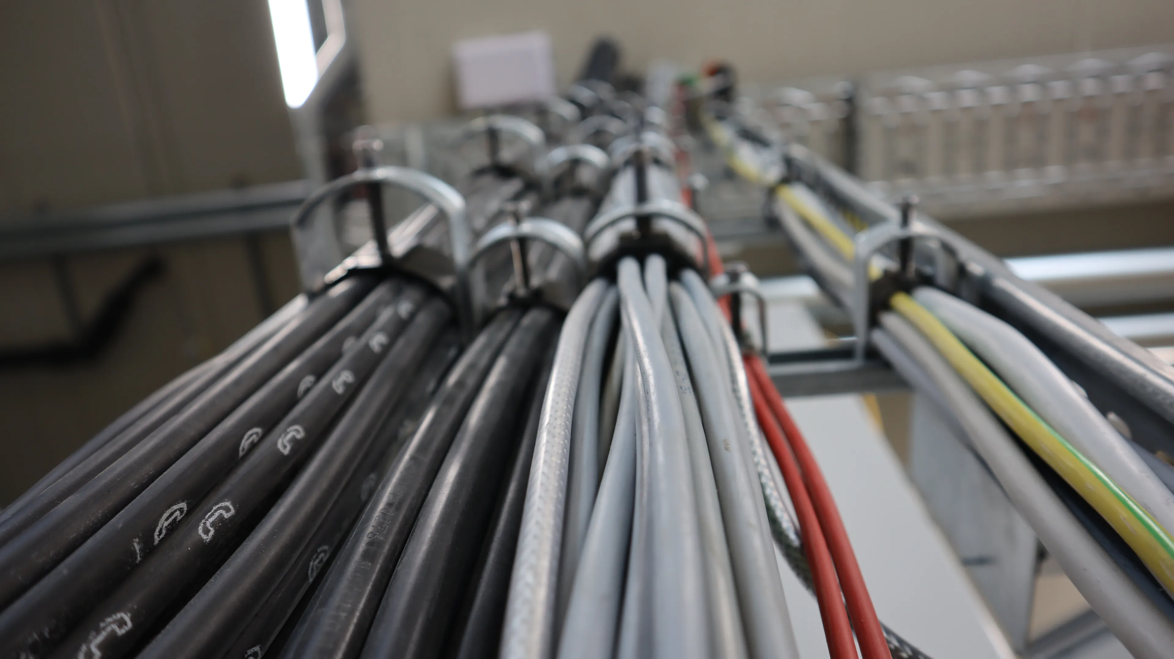 Mehrere sauber verlegte Energie-, Steuerungs- und Datenkabel in einer industriellen Anlage. Die strukturierte Kabelführung sorgt für eine sichere Stromversorgung, Signalübertragung und Vernetzung technischer Systeme sowie Automatisierungskomponenten.