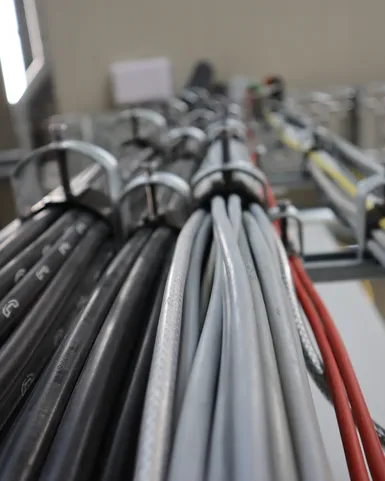 Mehrere sauber verlegte Energie-, Steuerungs- und Datenkabel in einer industriellen Anlage. Die strukturierte Kabelführung sorgt für eine sichere Stromversorgung, Signalübertragung und Vernetzung technischer Systeme sowie Automatisierungskomponenten.