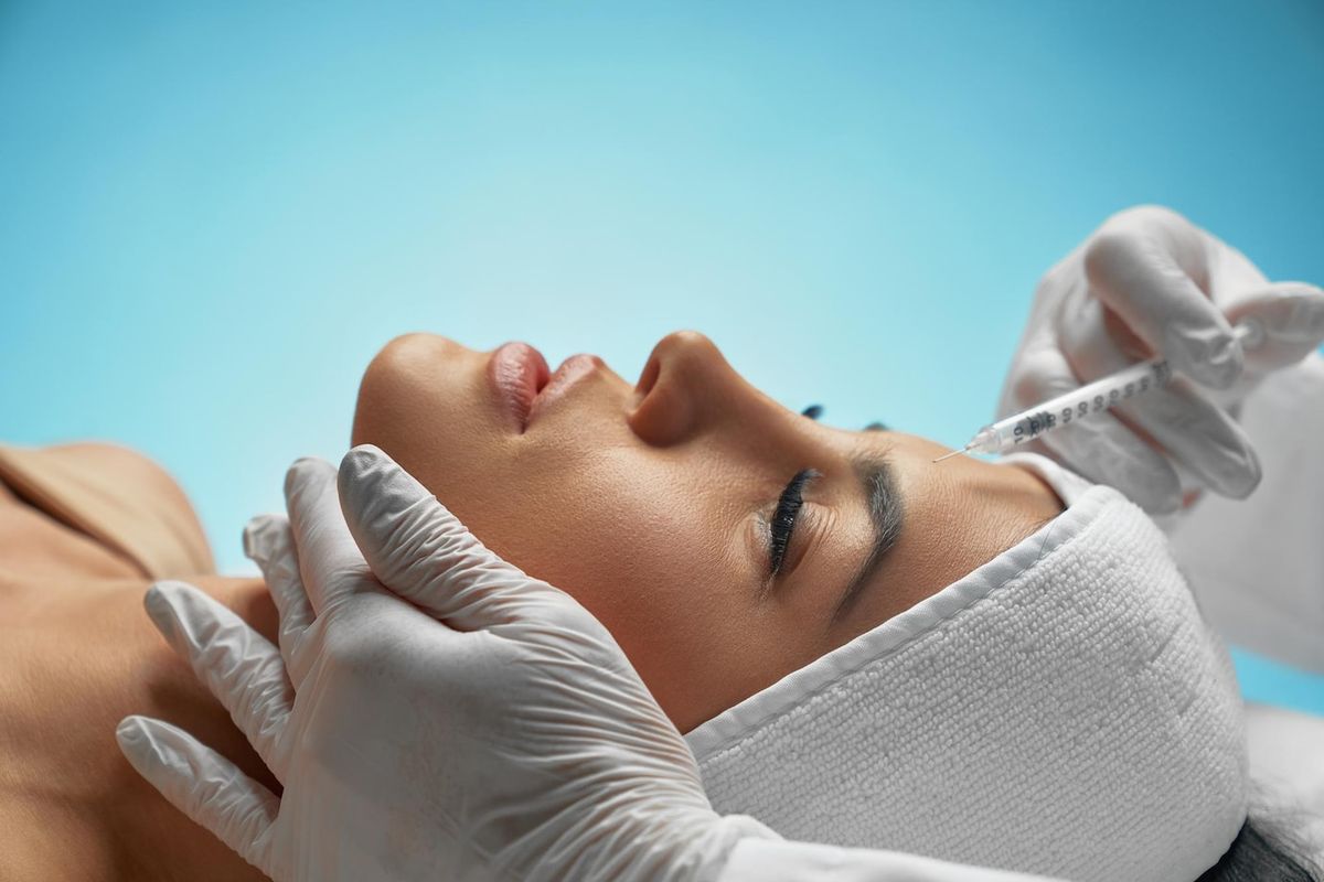 Mujer recibiendo tratamiento facial con inyecciones de Toxina Botulínica